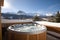 Outdoor jacuzzi in winter in the mountains with a view of the snow-capped mountains