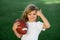 Outdoor kids sport activities. Child boy with american football, rugby ball. Cute portrait of a american football player