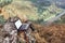 An outdoor laptop stands on a high-bank rock