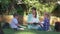 Outdoor lesson, happy classmate learners boy and girl with educator female read books and chat during teaching