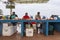 Outdoor male and female fish vendors seen sitting behind their products next to sea lion and pelicans