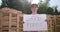 Outdoor of men activist with Save the forest ecology poster. In background chopped trees