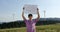 Outdoor of men activist with Save forest ecology poster. In background forest and wind turbine