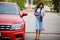 Outdoor photo of gorgeous woman posing near orange suv car