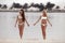 Outdoor photo of two sexy bikini girls models in fashion swimsuits on tropical beach at Maldives island. Slim ladies with tan