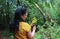 Outdoor picture of a beautiful young woman holding yellow flowers