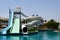 Outdoor pool with blue clear warm water and water slides pipes on vacation in a tropical warm exotic country, a seaside resort wit