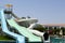 Outdoor pool with blue clear warm water and water slides pipes on vacation in a tropical warm exotic country, a seaside resort wit