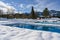 Outdoor Pools at winter time with snow around at snowy Rest Area with Deckchairs in Resort in Bavaria, Germany on winter day