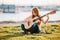 Outdoor portrait of adorable 9 year old kid girl playing guitar outdoors