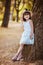 Outdoor portrait of adorable little girl dressed up in white dress