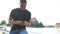 Outdoor portrait of an African American man with a smartphone in his hands. Black student reads messages on his phone