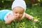 Outdoor portrait of a baby on all fours. crawling on knees child on the grass in a summer park.