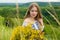 Outdoor portrait of beautiful blonde woman, attractive young girl in camomile field with flowers. Young beautiful girl in the fiel