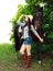 Outdoor portrait of beautiful cowgirl with horse in green