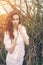 Outdoor portrait of a beautiful redhead curly girl