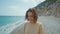 Outdoor portrait beautiful summer woman walking pebble beach and enjoying weekend at seaside with cliffs by the sea