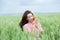 Outdoor portrait of a beautiful woman smelling  poppy flowers in a wheat field