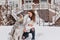 Outdoor portrait of blissful european woman enjoying winter weekend with husky dog. Long-haired cute girl kissing her