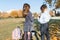 Outdoor portrait of boy and girl pupils in primary school. Kids in headphones with mobile phones