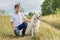 Outdoor portrait of boy teenager with white dog