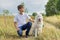 Outdoor portrait of boy teenager with white dog