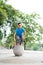 Outdoor portrait of a cute Malaysian little boy trying to jump from a concrete ball at the park