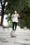 Outdoor portrait of a cute Malaysian little girl with long hair jumping from the concrete ball in the park