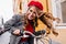 Outdoor portrait of emotional curly lady exploring town on bike. Sensual french girl in red beret having fun, riding on