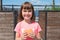 Outdoor portrait of a girl with a cheeseburger in her hands in the park on a sunny summer day.  Unhealthy food, fast fat food