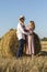 Outdoor portrait of happy couple in love on hay bale background