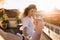 Outdoor portrait of happy touched young woman in white shirt with male hand holding ring on foreground. Attractive cute