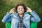 Outdoor portrait of happy upbeat dark-skinned male with bristle and afro haircut lying on bean bag chair or grass