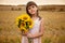 Outdoor portrait of a little girl with a bouquet of sunflower in a field posing at the camera