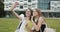 Outdoor portrait of pretty happy girls making video call to her best friend relaxing in the courtyard. Female bloggers