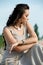 Outdoor portrait of romantic charming lady with closed eyes relaxing on the beach on a sunny summer day