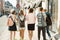 Outdoor portrait of school teacher and group of teenagers high school students. Children walking with teacher, view from the back