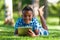 Outdoor portrait of student black boy using a tactile tablet - A