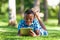 Outdoor portrait of student black boy using a tactile tablet