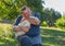 Outdoor portrait of sweet friends - senior man and his cute white goose on the hands