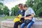 Outdoor portrait of two talking teenagers with smartphone