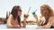 Outdoor portrait of two young cute girlfriends in sunglasses and swimsuits with cocktail glass chilling in swimming pool