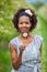 Outdoor portrait of a young beautiful african american woman holding a dandelion flower - Black people