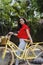 Outdoor portrait of young beautiful girl 19 to 25 years old posing in street. Brunette. riding a retro styled bicycle. Wearing red