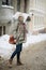 Outdoor portrait of young beautiful happy girl posing on street. Model wearing stylish warm clothes. Magic snowfall. Winter holida