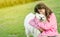 outdoor portrait of young caucasian girl with her pet dog, child owner with white fluffy japanese spitz puppy