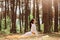Outdoor profile portrait of slim female practicing yoga in forest, dresses white sportswear, doing cobra pose on karemat in open