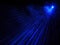 Outdoor projector shines bright neon blue beams in the dark. Laser show. Blurred image