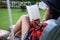 Outdoor Reading Retreat: Latina Woman Enjoying a Book on a Countryside Swing