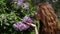 Outdoor recreation. Girl with lilac flowers. Botanical garden in spring.